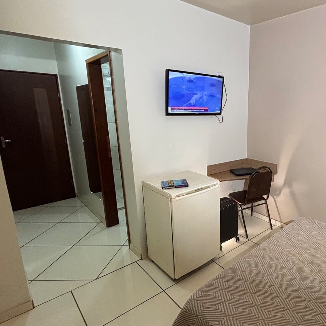 TV, frigobar e mesa no apartamento Luxo do Hotel Galli