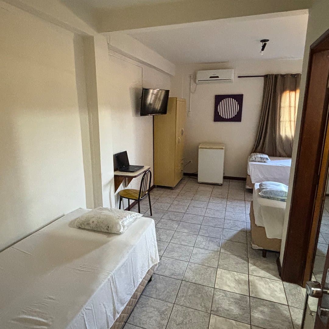 Guarda-roupa, TV e frigobar no apartamento Superluxo reformado do Hotel Galli