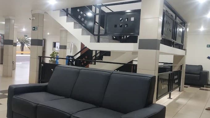 Recepção do Hotel Galli, com sofá e escada de acesso aos andares