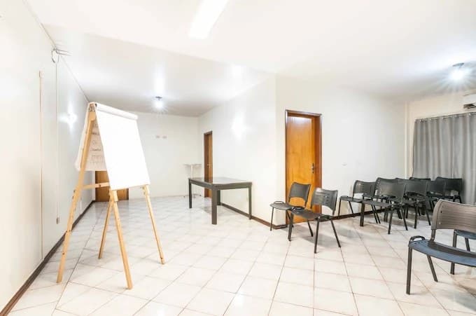 Sala de reunião Prata do Hotel Galli, com flipchart, mesa e cadeiras